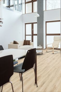 a living room filled with white furniture and wooden flooring on top of a hard wood floor