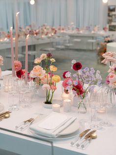 the table is set with flowers and candles