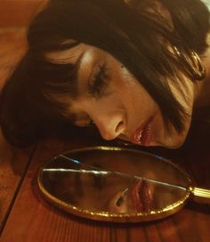 a woman looking through a magnifying glass with her face close to the mirror