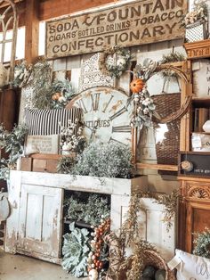 an old fashioned clock surrounded by wreaths and other decorations in a room with wooden walls