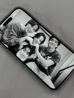 a black and white photo of four people on a cell phone case that is laying down