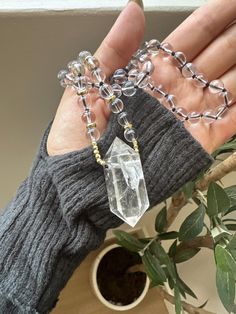 This stunning Clear Quartz Crystal Necklace is the perfect blend of elegance and spiritual energy. Featuring a striking, raw clear quartz point pendant, this necklace is hand-strung with clear quartz beads and gold-tone accents, adding a radiant touch to any outfit. The necklace is both a statement piece and a tool for spiritual healing, designed to amplify positive energies and promote mental clarity. Product Details: *Crystal: Natural Clear Quartz Point *Pendant Size: Approx. 5cm *Chain: Clear Quartz Beads with Gold-tone Spacer Beads *Chain Length: 21cm *Handmade with Love Properties of Clear Quartz: Clear Quartz is known as the "Master Healer," amplifying energy, thoughts, and the effects of other crystals. It is a highly prized stone for those looking to enhance their focus, clarity, a Raw Clear Quartz, Crystal Point Necklace, Natural Gemstone Necklace, Clear Quartz Point, Quartz Crystal Necklace, Spiritual Energy, Quartz Beads, Mental Clarity, Spiritual Healing