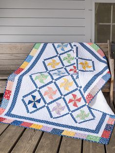 a quilted blanket sitting on top of a wooden bench