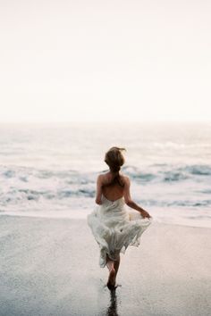 a woman is walking on the beach with her dress blowing in the wind and text that reads ellen cree rated