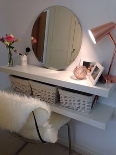 a white desk with a mirror and some baskets on it