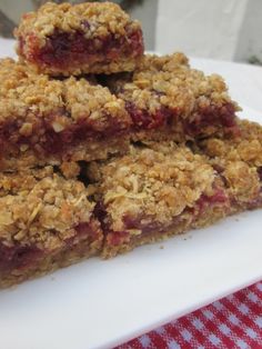 three pieces of granola on a plate with a red and white checkered tablecloth