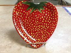 a red strawberry shaped bowl sitting on top of a counter