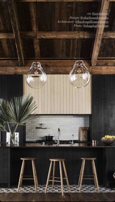 an image of a kitchen setting with bar stools and lights hanging from the ceiling