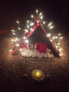 the elf is sleeping in his tent with christmas lights