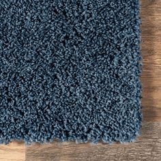 a blue rug on top of a wooden floor next to a wood flooring board