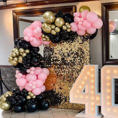 the balloon arch is decorated with pink, black and gold balloons for an anniversary celebration