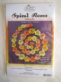 a package of paper roses sitting on top of a white tablecloth covered in orange, yellow and pink flowers