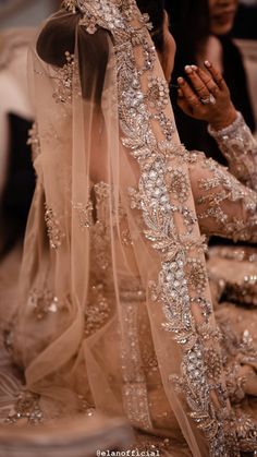 the back of a woman's wedding dress is covered in sequins and beads