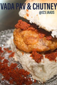 a close up of food on a plate with words above it that reads vada pav & chutney