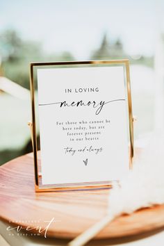 a sign that says in loving memory on it sitting on top of a wooden table