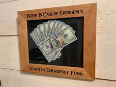 a wooden frame with money in it and the words, break in case of emergency