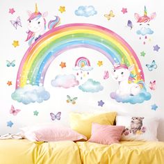 a bed room with a neatly made bed and a rainbow wall decal