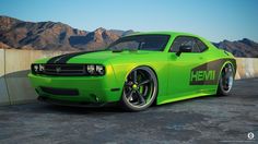 a green sports car parked in front of some mountains and hills with the word hem on it