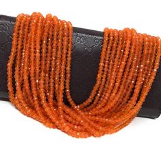 an orange beaded necklace on a black leather case