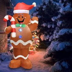 a large inflatable christmas ginger standing next to a tree