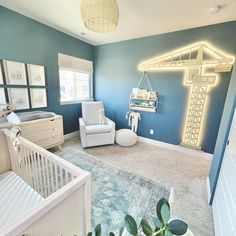 a baby's room with blue walls and white furniture