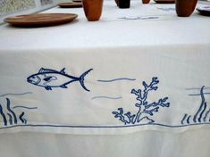 a white table cloth with blue fish on it