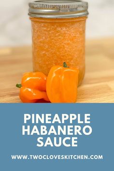 pineapple habanero sauce in a glass jar with two peppers on the side