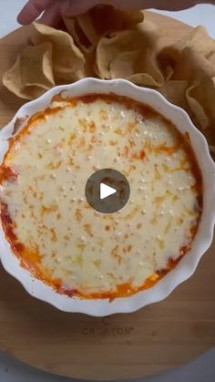 a person holding a bowl of food on top of a cutting board