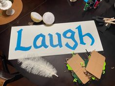 a sign that says laugh on it next to some scissors and other crafting supplies