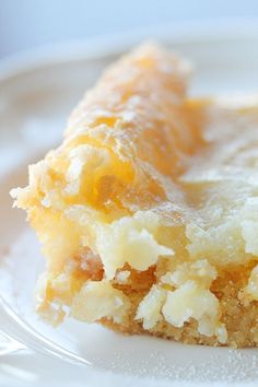 a close up of a piece of cake on a plate with icing and powdered sugar