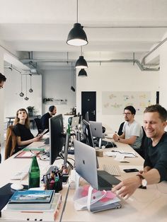 a group of people sitting around a table working on computers