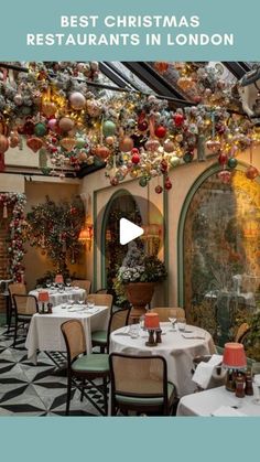 a restaurant with christmas decorations hanging from the ceiling and tables set up in front of it