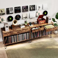 a record player is sitting on top of a wooden table with records and vinyls