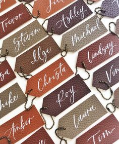 the name tags are all different colors and font on each piece of leather, which is attached to a chain