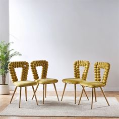 three yellow chairs sitting next to each other on top of a rug