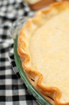 an uncooked pie sitting on top of a checkered table cloth