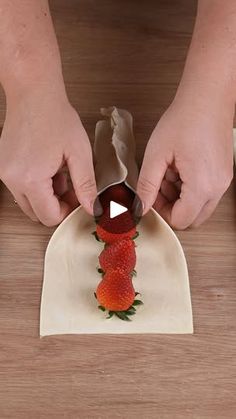 someone is cutting up some strawberries on a plate