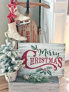 a wooden sign that says merry christmas next to a small tree