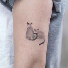 a cat and mouse tattoo on the arm