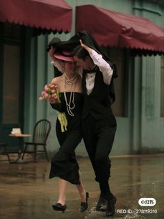 a man and woman dancing in the rain