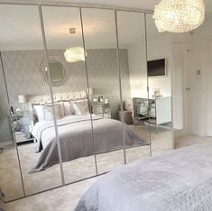 a bedroom with mirrored walls and a large bed in the middle is seen through three mirrors