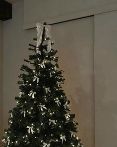 a small black christmas tree with white bows