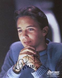 an autographed photo of a young man with his hand resting on his chin