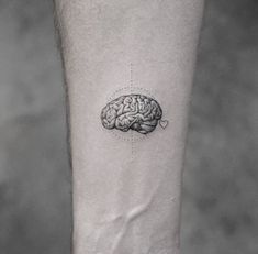 a black and white photo of a person's leg with a brain tattoo on it