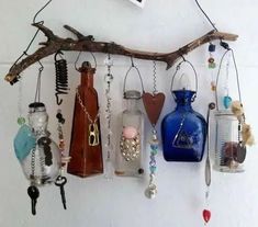 there are many glass bottles hanging on the wall with key chains attached to each one