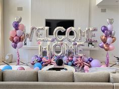 a living room filled with furniture and balloons in the shape of letters that spell out welcome home