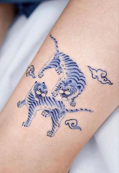 a tiger tattoo on the arm of a woman