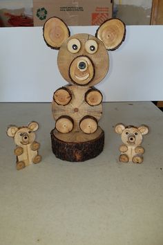 a wooden bear and two smaller bears on a table