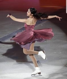 a woman in a short dress skating on an ice rink