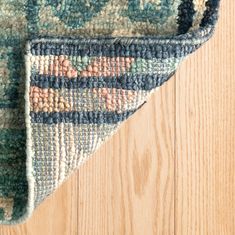 an area rug on top of a wooden floor next to a wood flooring board